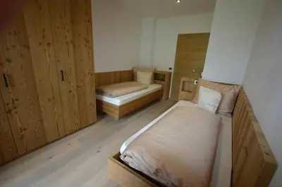 a small room with two beds and two cabinets at Hilpoldhof in Castelrotto