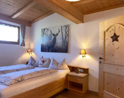 a bedroom with a bed with a deer picture on the wall at Untertalhof in Castelrotto