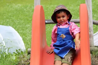 a young child is sitting on a slide at Untertalhof in Castelrotto