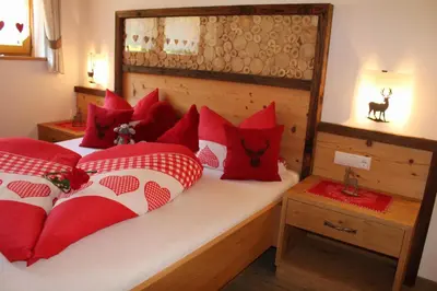 a bedroom with a bed with red pillows at Untertalhof in Castelrotto