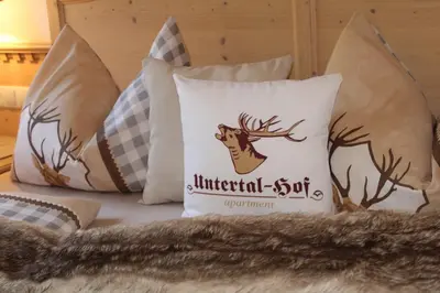 a pile of pillows with a deer on a bed at Untertalhof in Castelrotto