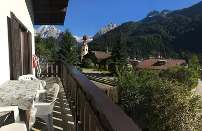 a balcony of a house with a table and chairs at Appartamento Piè in Canazei
