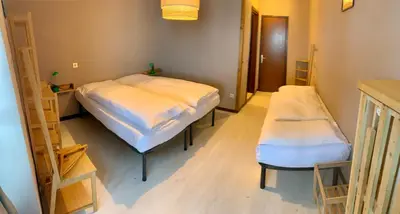 a room with two beds and shelves in it at Appartamento Piè in Canazei
