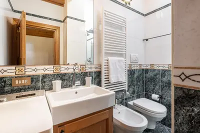 a bathroom with a sink and a toilet at ATTICO Lodge in Cortina dʼAmpezzo