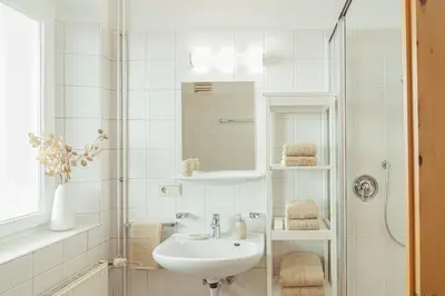 a white bathroom with a sink and a shower at Alter Schlachthof in Bressanone