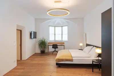 a bedroom with a bed and a desk and a window at Alter Schlachthof in Bressanone
