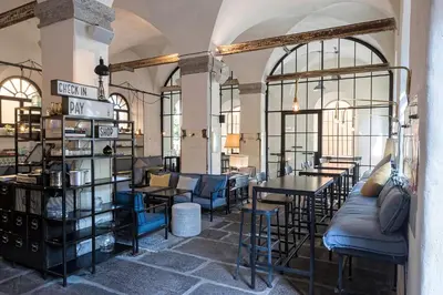 a store with tables and chairs in a room with windows at Alter Schlachthof in Bressanone