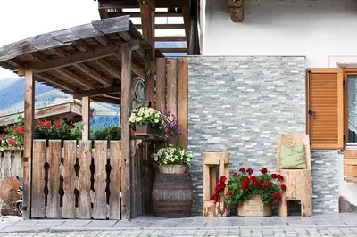 a building with potted plants and a wooden fence at Hölzlhof in Brunico