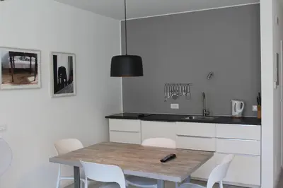 a kitchen with a wooden table and white chairs at Apartments Rathaus 008 - Municipio 008 in Bolzano