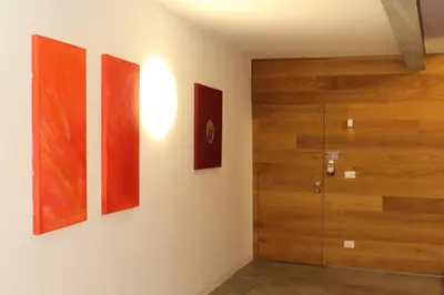 a room with four paintings on the wall and a door at Apartments Rathaus 008 - Municipio 008 in Bolzano