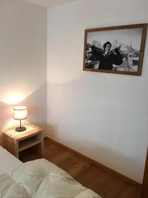a bedroom with a bed and a picture on the wall at Grohmann in Campitello di Fassa