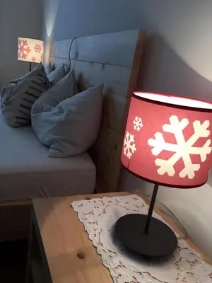 a red lamp sitting on a table next to a bed at Grohmann in Campitello di Fassa