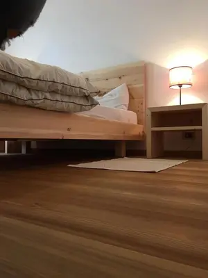a bedroom with a bed and a lamp on a table at Grohmann in Campitello di Fassa