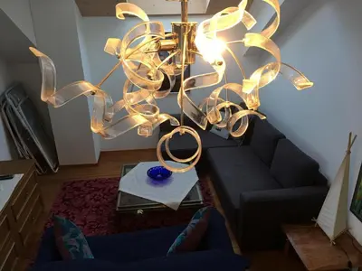 a chandelier in a living room with a couch at Grohmann in Campitello di Fassa