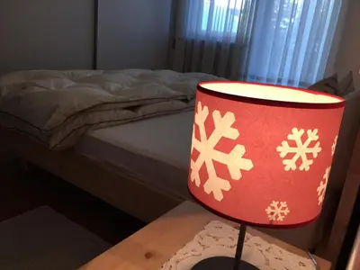 a red lamp sitting on a table next to a bed at Grohmann in Campitello di Fassa