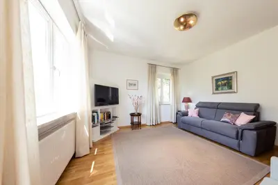 a living room with a blue couch and a tv at Haus Dorfblick in Caldaro