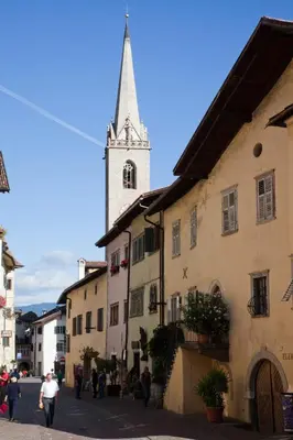 a church with a steeple on top of a building at Haus Dorfblick in Caldaro