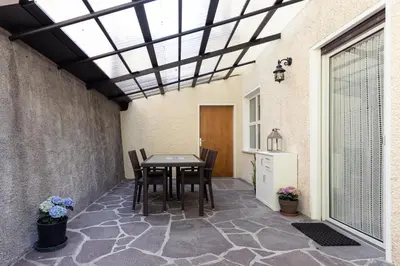 a patio with a table and chairs and a window at Haus Dorfblick in Caldaro