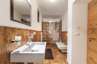 a bathroom with two toilets and a sink at Agriturismo Apartments Tuene in Ortisei