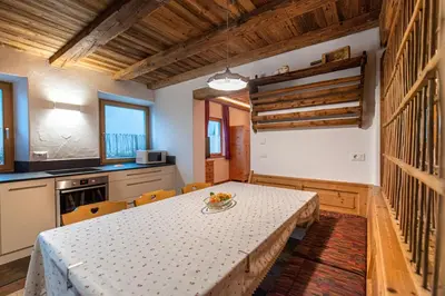 a kitchen with a table and chairs in a room at Agriturismo Apartments Tuene in Ortisei