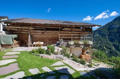 a log house with a garden in front of it at Agriturismo Apartments Tuene in Ortisei