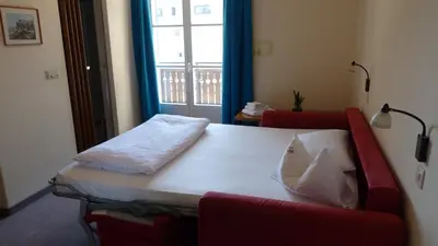 a bed sitting in a room with a window at Pension Runer in Terlano