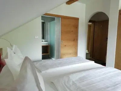 a white bed in a room with a mirror at Pension Runer in Terlano