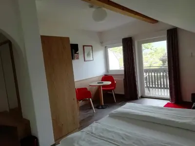 a bedroom with a bed and a window and a table at Pension Runer in Terlano