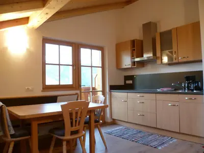 a kitchen with a wooden table and a dining room at Parlunkhof in Castelrotto