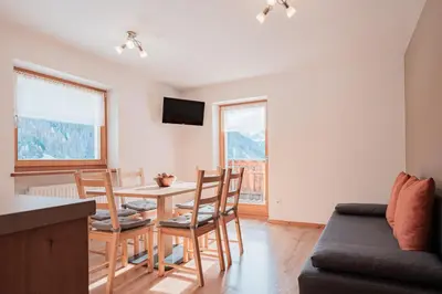a living room with a table and chairs and a couch at Lüch da Morgnun in San Vigilio Di Marebbe