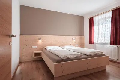 a bedroom with a bed in a room with a window at Lüch da Morgnun in San Vigilio Di Marebbe