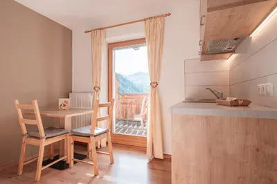 a small kitchen with a table and a window at Lüch da Morgnun in San Vigilio Di Marebbe
