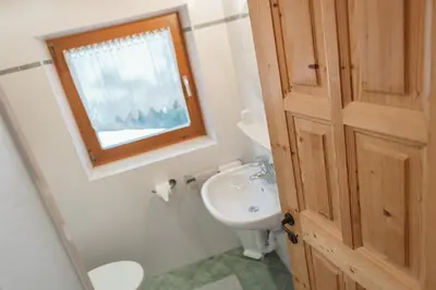 a bathroom with a sink and a toilet and a window at Residence Karnutsch in Santa Valburga St. Walburg