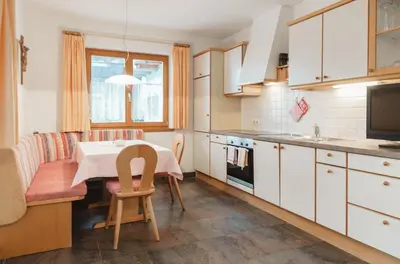 a kitchen with a table and a dining room at Residence Karnutsch in Santa Valburga St. Walburg