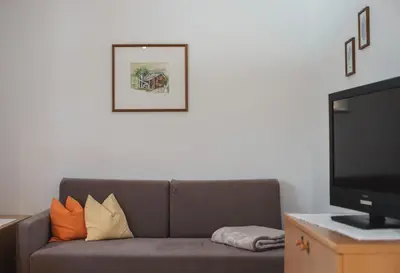 a living room with a couch and a flat screen tv at Residence Karnutsch in Santa Valburga St. Walburg