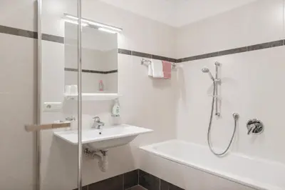 a white bathroom with a sink and a shower at Residence Karnutsch in Santa Valburga St. Walburg