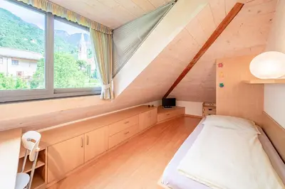 a small bedroom with a bed and a window at Haus Piger in Termeno