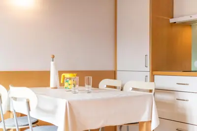 a white table with chairs and glasses on it at Haus Piger in Termeno