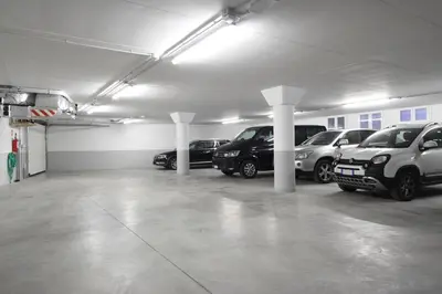 a parking garage with several cars parked in it at Garni Maso San Michele in Cavalese