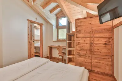a bedroom with a bed and a desk at Garni Maso San Michele in Cavalese