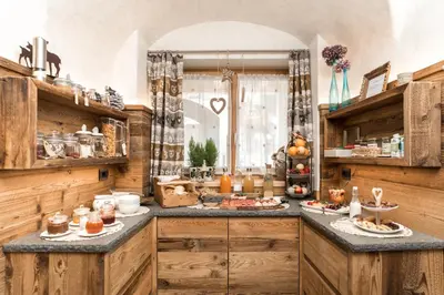 a kitchen with wooden cabinets and a counter top at Garni Maso San Michele in Cavalese