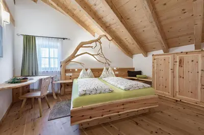 a bedroom with a bed in a room with a desk at Platzbon in Bressanone