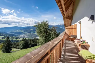 a wooden balcony with a view of mountains at Platzbon in Bressanone