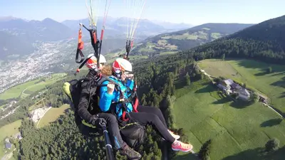 two people are hanging from a parachute at Platzbon in Bressanone