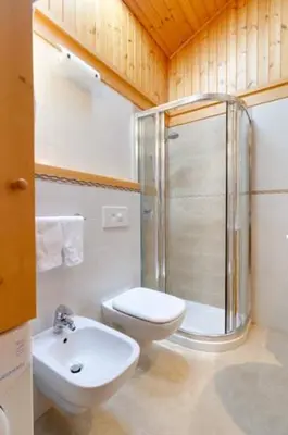a small bedroom with a bed in a wooden cabin at Appartamento Saslonch 21 in Moena