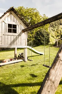 a play structure with swings in a yard at Hotel Nussbaumerhof *** in Rodengo