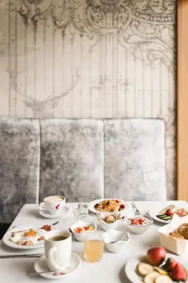 a table with plates of food and cups of coffee at Hotel Nussbaumerhof *** in Rodengo
