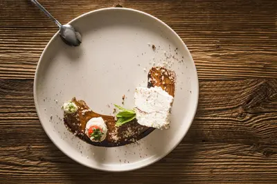 a plate of dessert on a table with a spoon at Hotel Nussbaumerhof *** in Rodengo