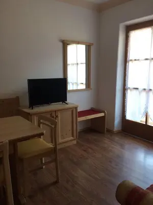 a living room with a television and a table and chairs at Biohof Niedereben in Rablà