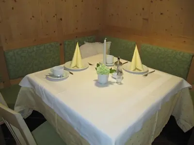 a table with three napkins and candles on it at Hotel & Residence Rebhof in Tirolo